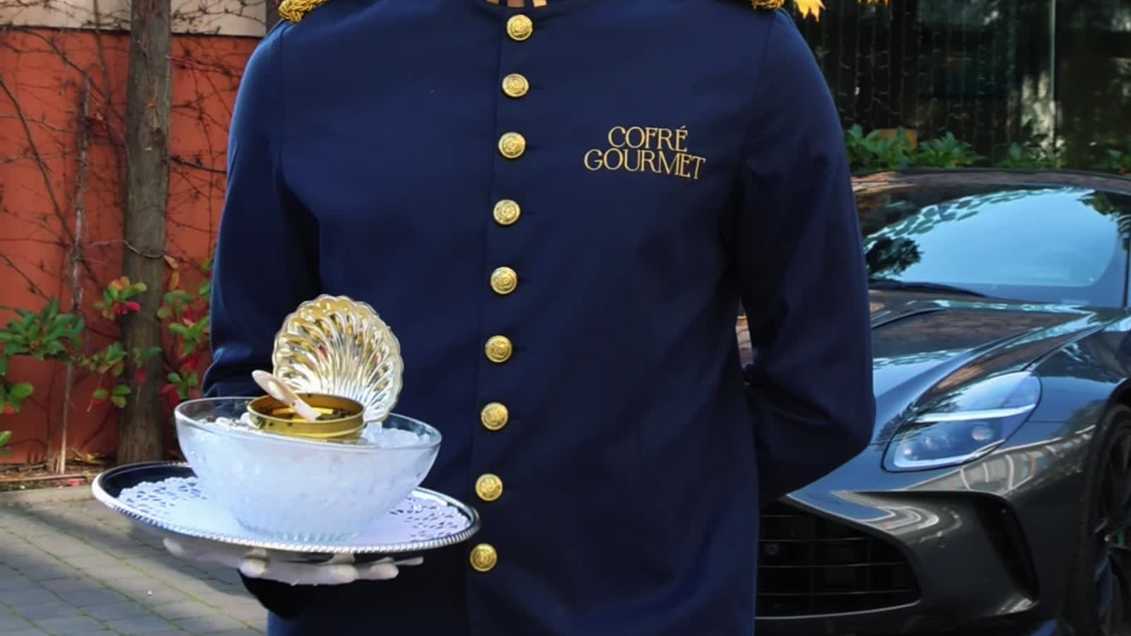 Servicio de caviar Cofré junto a un Aston Martin